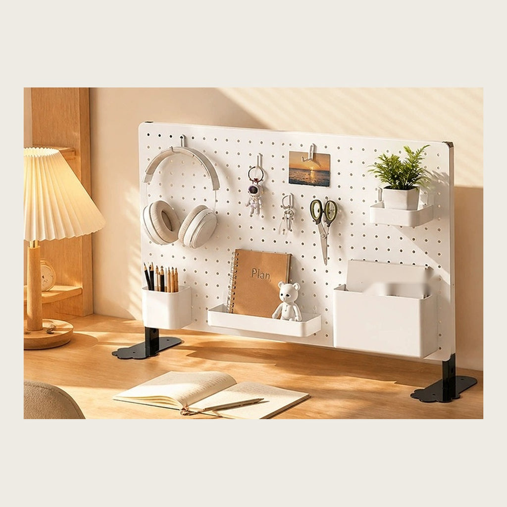 The pegboard panel standing on a home office desk, holding headphones and pens