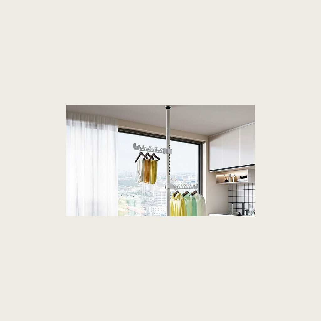 The tension pole set between floor and ceiling with shirts on the fold-out rails
