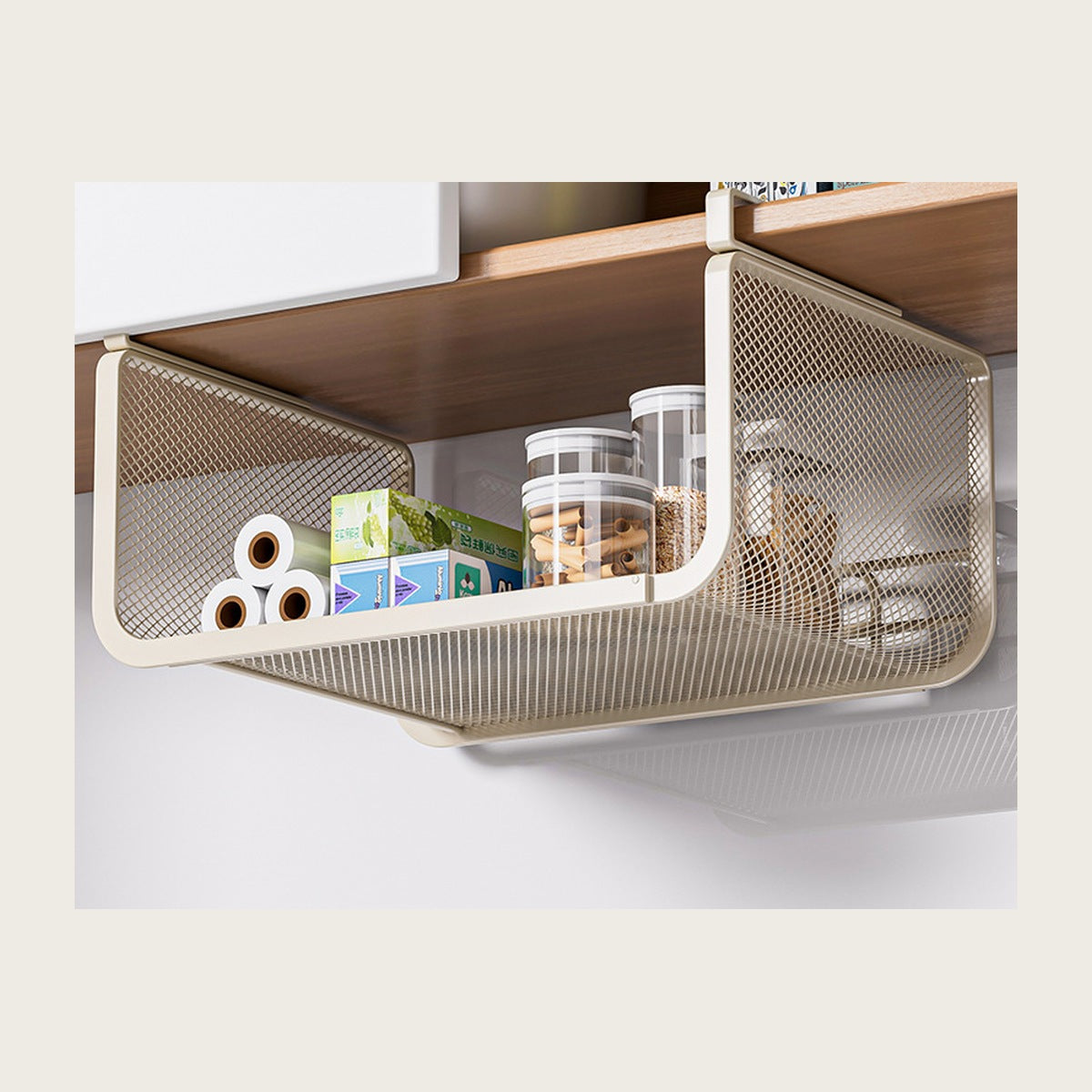 The basket hanging under a kitchen shelf, holding rolls and jars